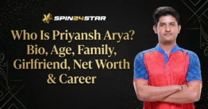 A promotional graphic for Spin24Star featuring a portrait of Priyansh Arya, a young man with dark hair standing with his arms crossed while wearing a red and blue patterned sports jersey. On the left side, large gold text reads, "Who Is Priyansh Arya? Bio, Age, Family, Girlfriend, Net Worth & Career." The background is dark with elegant gold geometric lines and subtle sparkling dust.